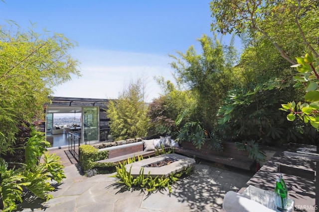 view of patio / terrace with a fire pit and a water view