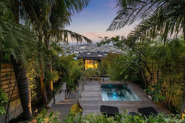 pool at dusk with a wooden deck