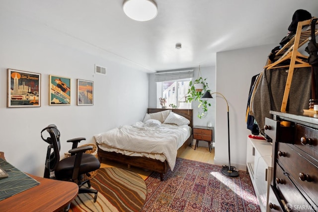 bedroom featuring visible vents and wood finished floors