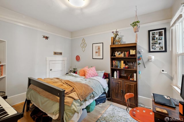 bedroom with wood finished floors and baseboards