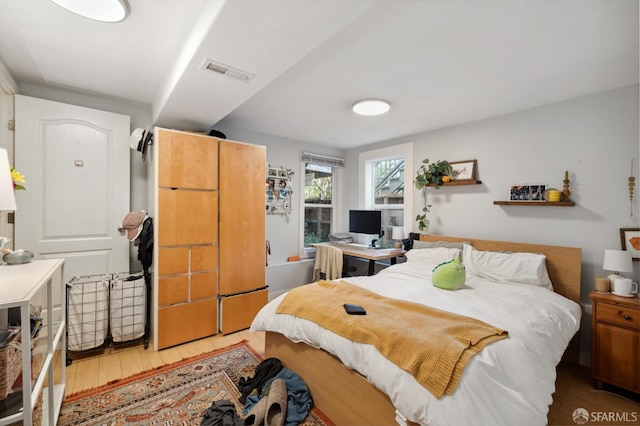 bedroom featuring visible vents and wood finished floors