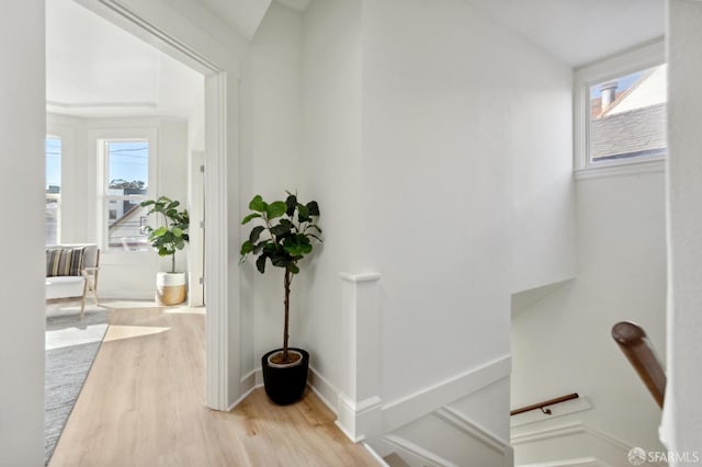 corridor with light wood finished floors and baseboards