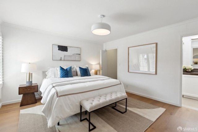 bedroom featuring crown molding, light wood-type flooring, and baseboards
