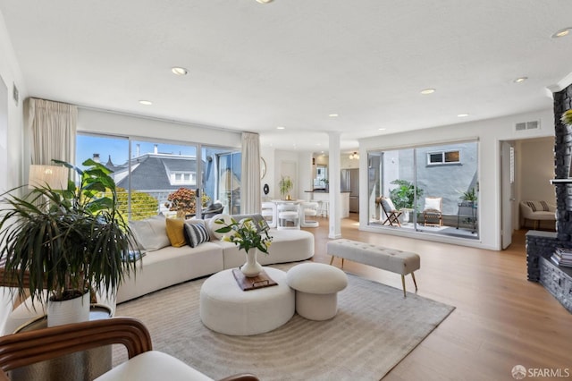 living room featuring ornate columns, wood finished floors, and recessed lighting