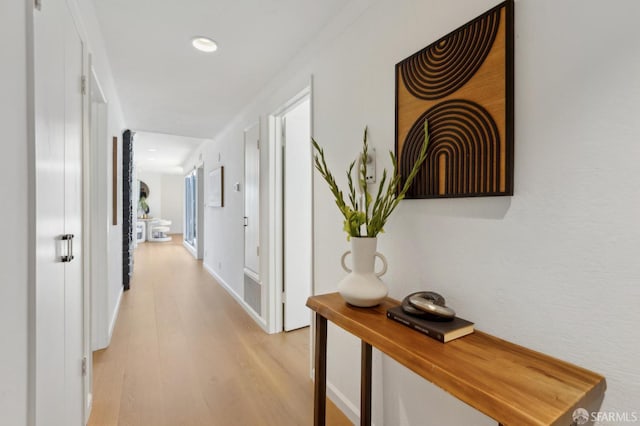 hall featuring light wood-style flooring and recessed lighting