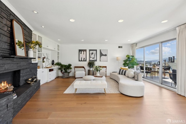 living room featuring a fireplace, wood finished floors, recessed lighting, and built in shelves