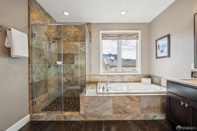 bathroom with vanity and shower with separate bathtub