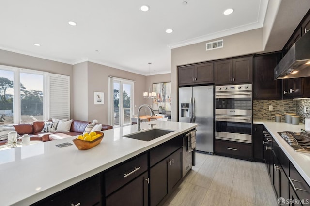 kitchen with sink, stainless steel appliances, decorative backsplash, dark brown cabinets, and ornamental molding