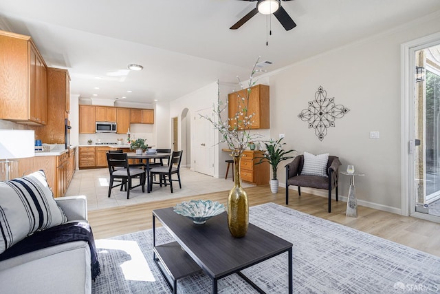 1845 Kern Mountain Way, Antioch, CA 94531 - living area featuring arched walkways, light wood-style flooring, ceiling fan, ornamental molding, and baseboards