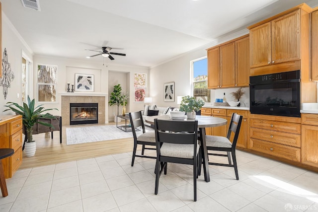 1845 Kern Mountain Way, Antioch, CA 94531 - dining space featuring ceiling fan, ornamental molding, a glass covered fireplace, and light tile patterned floors