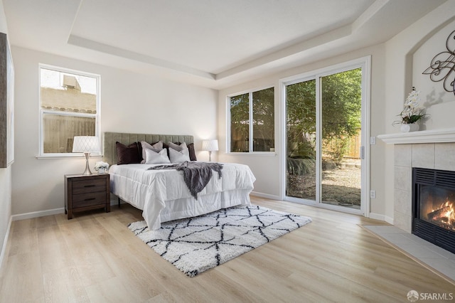 1845 Kern Mountain Way, Antioch, CA 94531 - bedroom featuring a raised ceiling, wood finished floors, access to outside, and a tiled fireplace