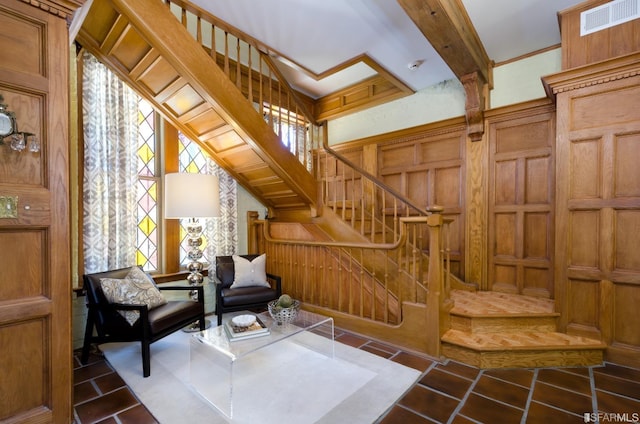 living area with wooden walls and beamed ceiling