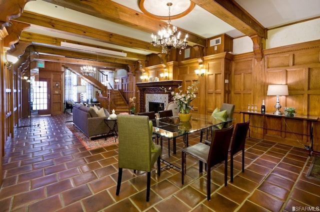 dining space with an inviting chandelier, wood walls, and beamed ceiling