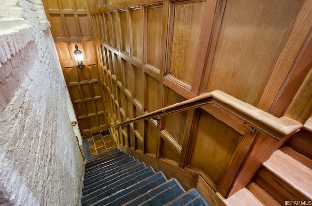 stairs featuring wood walls and hardwood / wood-style floors