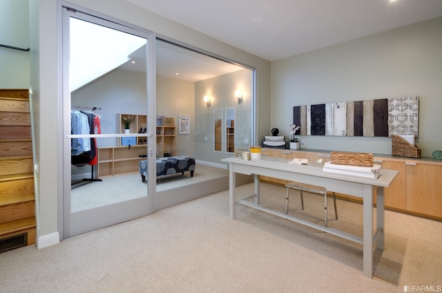 office with vaulted ceiling and light colored carpet