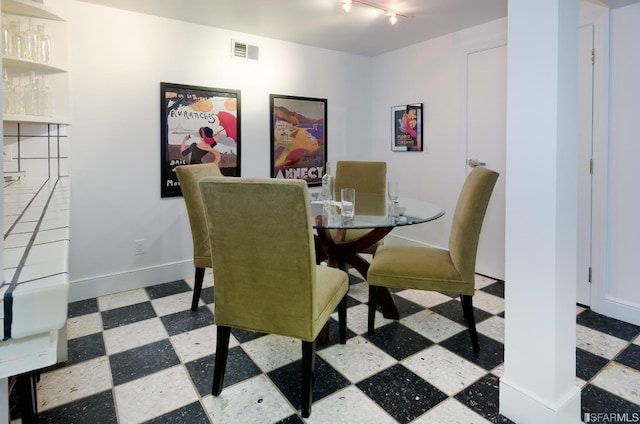 dining area with track lighting and indoor bar