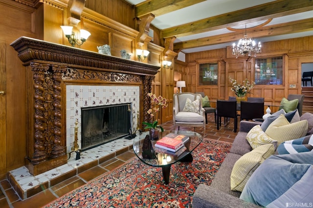 living room with wooden walls, a fireplace, a chandelier, and beam ceiling