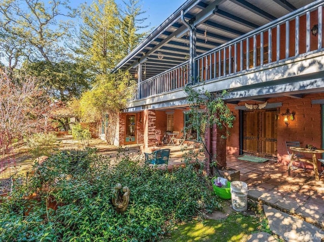 rear view of house featuring a patio and a balcony