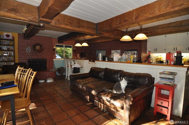 living room featuring a brick fireplace and beamed ceiling