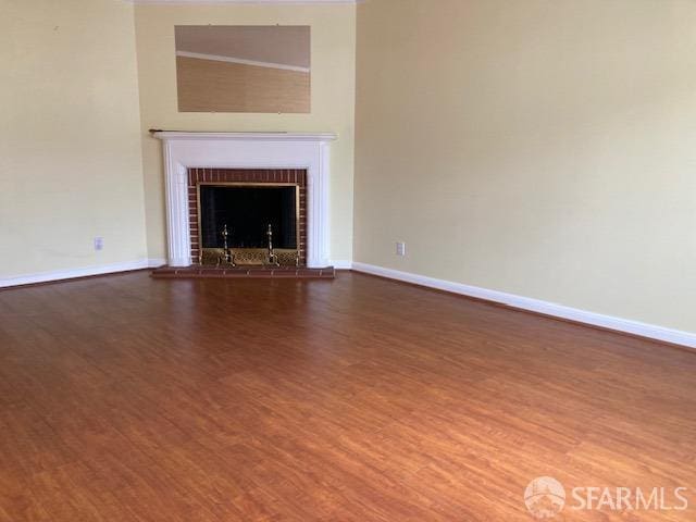 unfurnished living room with a brick fireplace and hardwood / wood-style floors