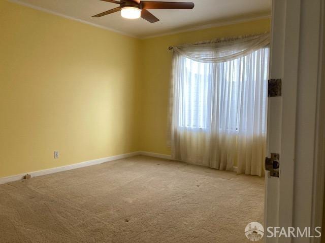 unfurnished room with carpet floors, ceiling fan, and crown molding