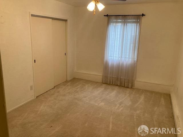 unfurnished bedroom featuring ceiling fan, a closet, and carpet