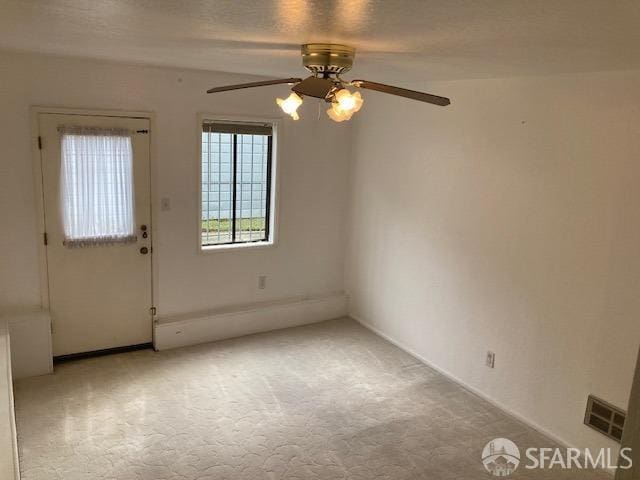 spare room featuring ceiling fan and light carpet