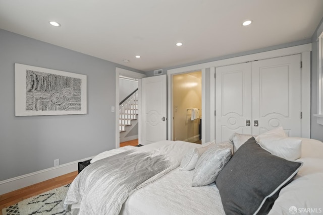 bedroom featuring recessed lighting, a closet, baseboards, wood finished floors, and ensuite bathroom