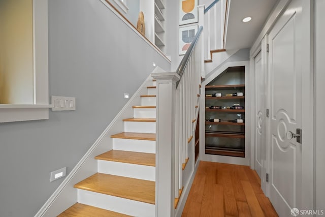 stairway with recessed lighting and wood finished floors
