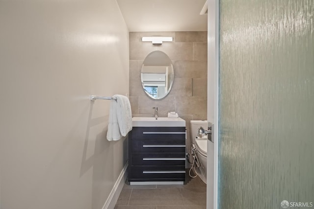 bathroom featuring tile patterned floors, vanity, toilet, and tile walls