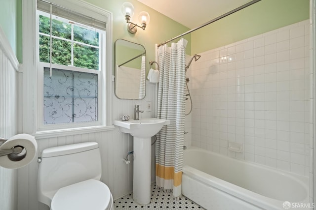 bathroom featuring toilet, a sink, shower / bathtub combination with curtain, and tile patterned floors
