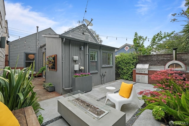 view of patio featuring a fire pit, grilling area, and exterior kitchen