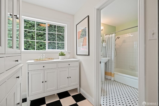 bathroom featuring tile patterned floors, shower / bath combo with shower curtain, and baseboards