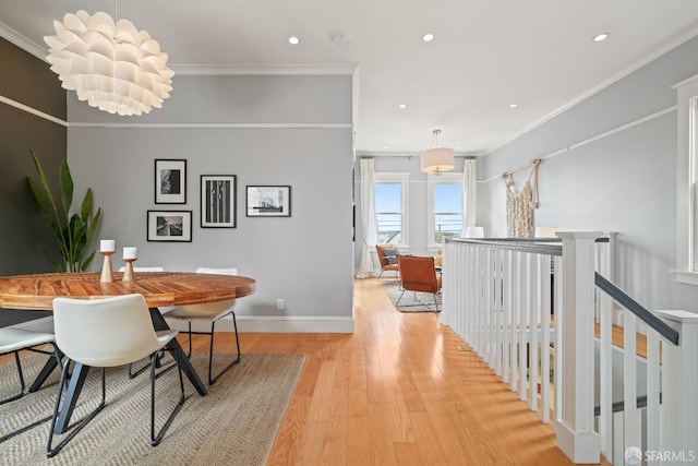 dining space with light wood-type flooring, recessed lighting, crown molding, and baseboards