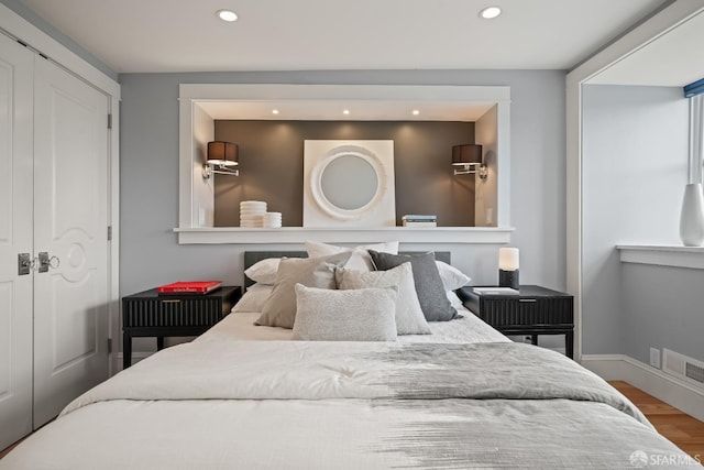 bedroom featuring recessed lighting, wood finished floors, a closet, baseboards, and visible vents