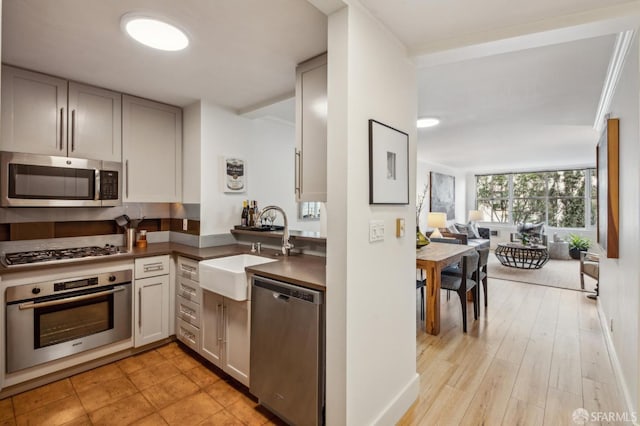 kitchen with stainless steel appliances, light hardwood / wood-style floors, and sink