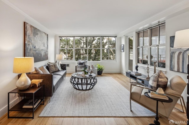 living room with ornamental molding, a wealth of natural light, and light hardwood / wood-style flooring