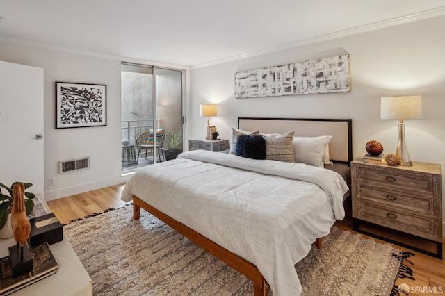 bedroom with hardwood / wood-style flooring, access to outside, and ornamental molding