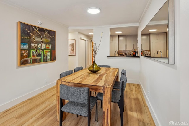 dining room featuring ornamental molding and light hardwood / wood-style floors