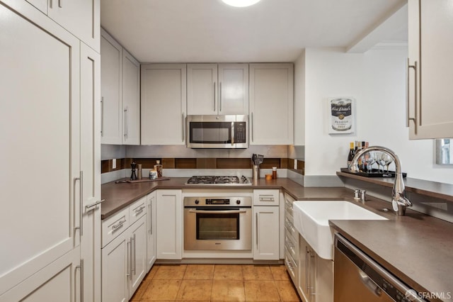 kitchen with white cabinetry, appliances with stainless steel finishes, sink, and light tile patterned floors