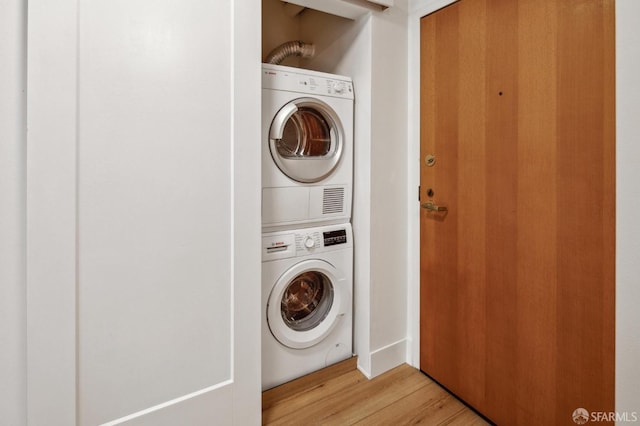 laundry area featuring light hardwood / wood-style floors and stacked washer / dryer