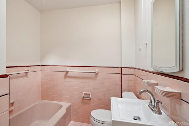 full bathroom with a wainscoted wall, a sink, toilet, and a bath