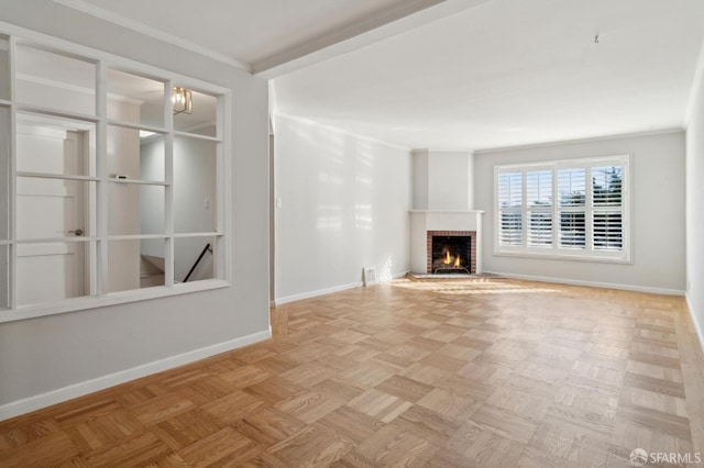 unfurnished living room featuring a brick fireplace, baseboards, and crown molding