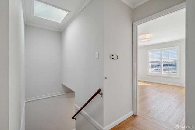 interior space featuring a skylight, wood finished floors, and baseboards