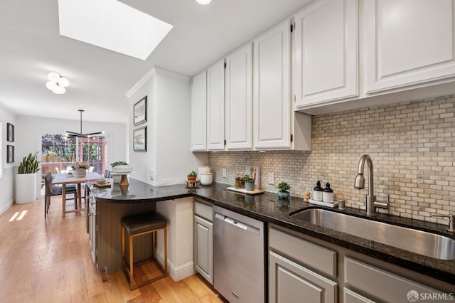 46 Otsego Ave, San Francisco, CA 94112 - kitchen featuring stainless steel dishwasher, white cabinetry, a peninsula, and light wood-style flooring