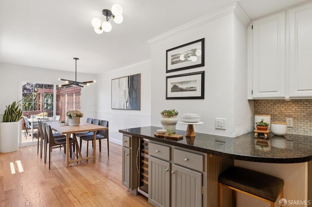 46 Otsego Ave, San Francisco, CA 94112 - kitchen featuring a chandelier, light wood-style flooring, wine cooler, decorative backsplash, and white cabinetry