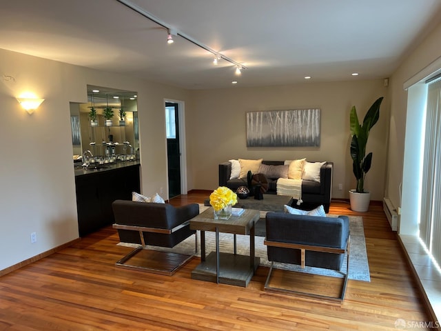183 Lakeshore Dr, San Francisco, CA 94132 - living area featuring wood finished floors, baseboards, a baseboard heating unit, rail lighting, and bar area