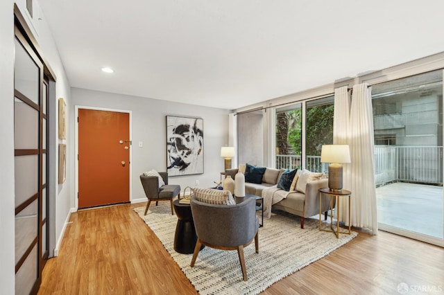 living room featuring baseboards, recessed lighting, and light wood-style floors