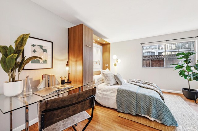 bedroom featuring baseboards and wood finished floors