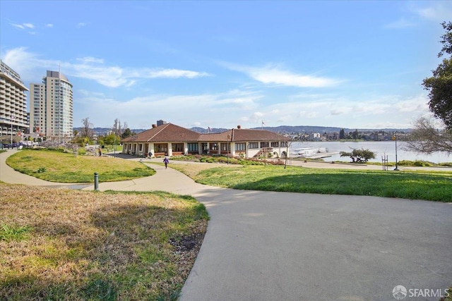 view of home's community with a water view and a yard